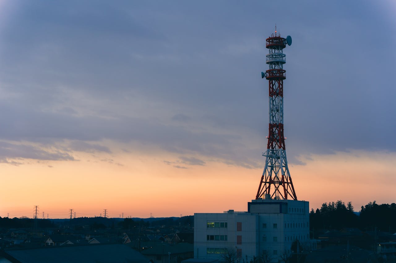 A tall communication tower stands against a colorful dusk sky, symbolizing modern connectivity.